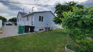 Back of property with a lawn and central AC unit