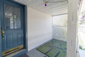 Front porch has two doors. One to the living room and one to the kitchen