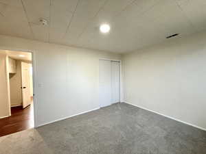Unfurnished bedroom with carpet flooring, a closet, and baseboards
