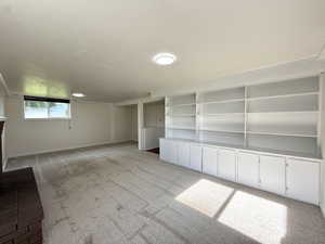 Unfurnished living room featuring light colored carpet and baseboards