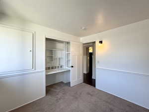 Unfurnished bedroom featuring carpet floors, a textured ceiling, and a closet