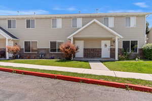 View of property featuring brick siding and a front yard