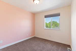 Spare room featuring carpet and baseboards