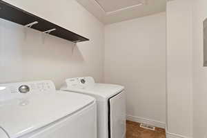 Laundry area featuring washing machine and clothes dryer and baseboards