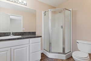 Full bathroom with a shower stall, vanity, and toilet