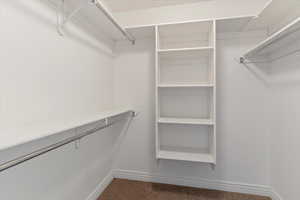 Walk in closet featuring dark carpet