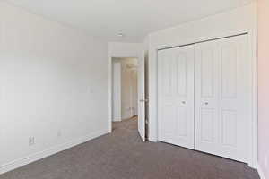 Unfurnished bedroom with carpet flooring, a closet, and baseboards