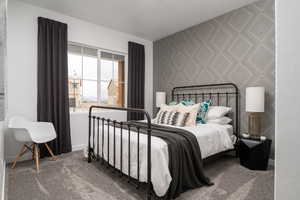 Bedroom featuring wallpapered walls, baseboards, and carpet