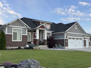 Craftsman house with board and batten siding, concrete driveway, and brick siding