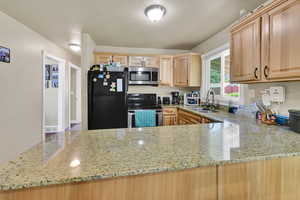 Another view of the kitchen with closeup of granite countertops.
