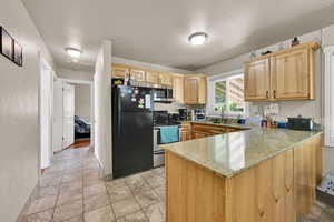 Kitchen with stainless steel appliances, sink, light colored cabinets, and granite countertops.