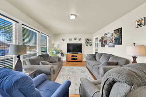 Another view of living room with light wood-style flooring and lots of natural light.