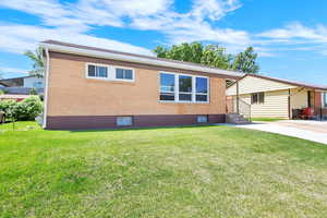 Another view of the front of house with brick exterior and front lawn.