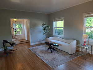 Living area featuring wood finished floors and crown molding