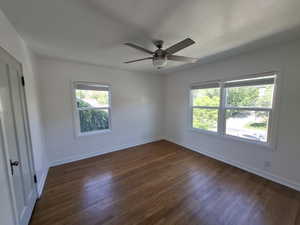 Spare room featuring dark wood finished floors and ceiling fan