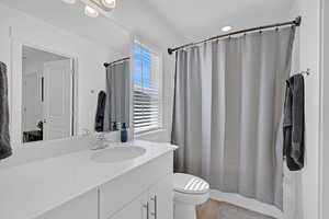 Full bathroom featuring vanity, toilet, and wood finished floors