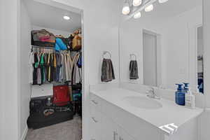 Bathroom featuring vanity and a walk in closet