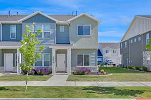 View of front of property with board and batten siding, a shingled roof, and a front yard