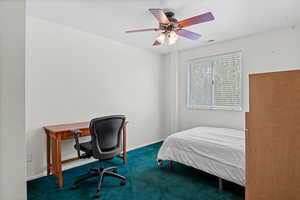 Bedroom featuring carpet floors, ceiling fan, and an office area
