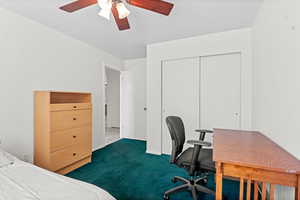 Bedroom featuring carpet flooring, a closet, ceiling fan, and an office area