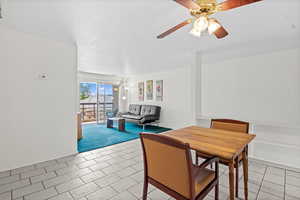 Dining space with ceiling fan and light tile patterned flooring