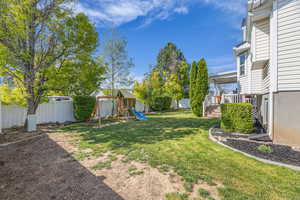 View of yard featuring a playground and a deck