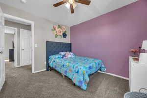 Carpeted bedroom featuring baseboards and a ceiling fan