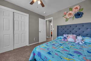Bedroom featuring carpet floors, ceiling fan, baseboards, and a closet