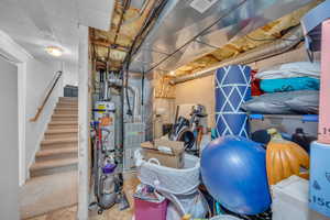 Unfinished basement with stairs and heating unit
