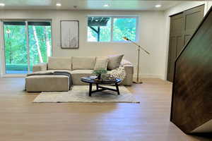 Living area with wood finished floors, baseboards, and recessed lighting
