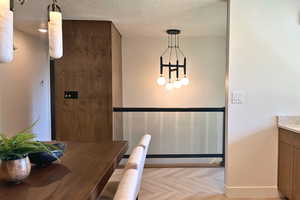 Dining room with a textured ceiling and baseboards