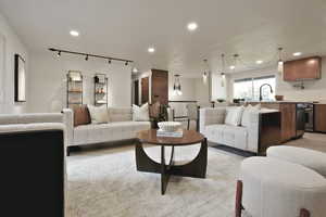 Living room with track lighting, recessed lighting, and light wood finished floors
