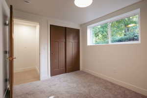 Unfurnished bedroom with carpet, baseboards, and a closet