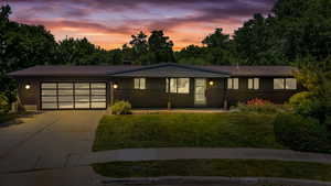 Single story home with concrete driveway, an attached garage, and a yard