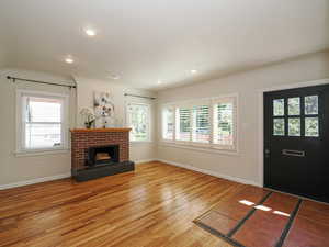 Unfurnished living room with light wood-type flooring, baseboards, a fireplace, and recessed lighting