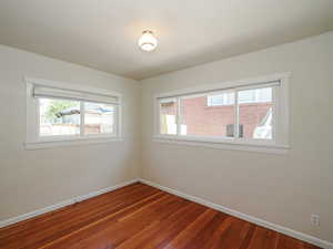 Spare room featuring baseboards and hardwood / wood-style floors