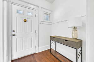 Foyer entrance featuring dark wood-style floors and baseboards