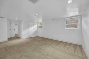 Carpeted empty room featuring recessed lighting and baseboards