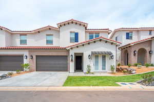 Mediterranean / spanish-style house with a garage, driveway, stucco siding, and a tile roof