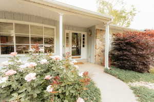 Entrance to property with stone siding and covered porch