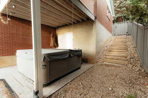 View of side of home with a hot tub and brick siding