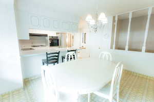 Dining space with a chandelier and light flooring
