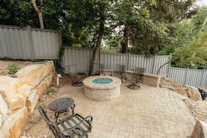 Fenced backyard featuring a patio area and a fire pit