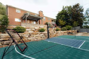 View of sport court with a pergola and basketball hoop