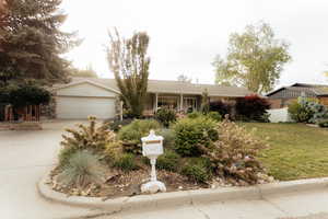 Single story home featuring an attached garage and concrete driveway