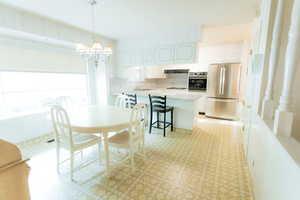 Dining area with a chandelier and light floors