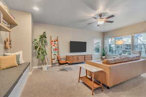 Living room featuring light carpet, a ceiling fan, baseboards, and recessed lighting