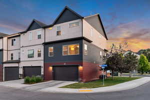 View of property with an attached garage, concrete driveway, and stucco siding