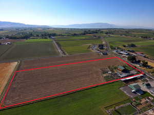 View of rural area with rows of crops, mountains, and property boundaries highlighted
