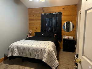 Carpeted bedroom with wood walls